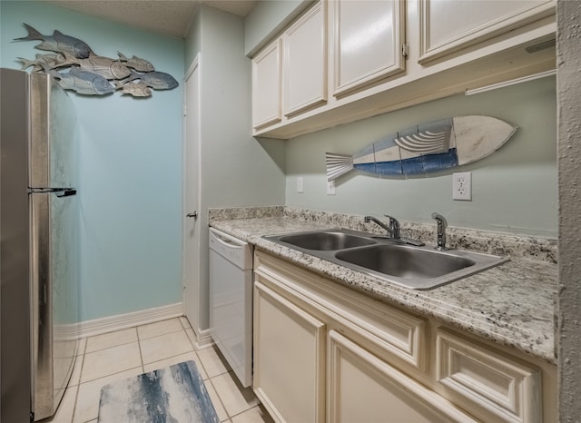 kitchen featuring white dishwasher, sink, and light tile patterned floors