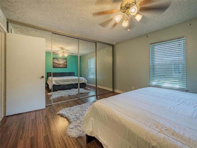 bedroom featuring dark hardwood / wood-style flooring, a textured ceiling, a closet, and ceiling fan