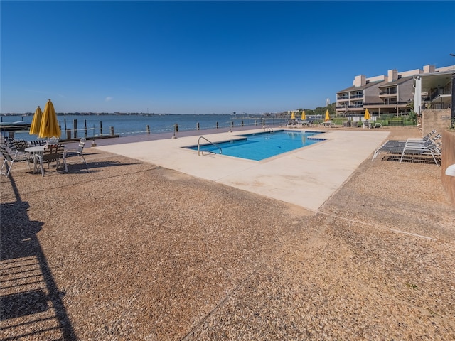 view of swimming pool with a patio area and a water view