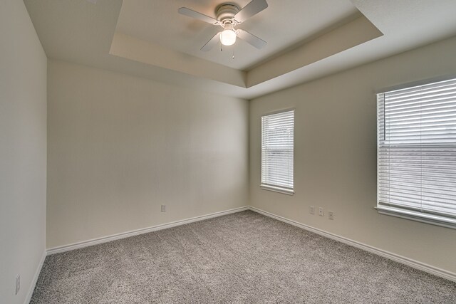 208 Cobblestone Cir, Red Oak, TX 75154 - spare room with baseboards, a ceiling fan, a tray ceiling, and carpet