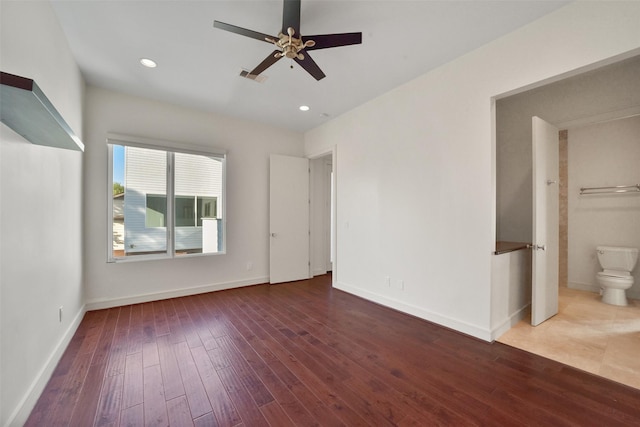 unfurnished bedroom with wood-type flooring, visible vents, baseboards, and ensuite bath