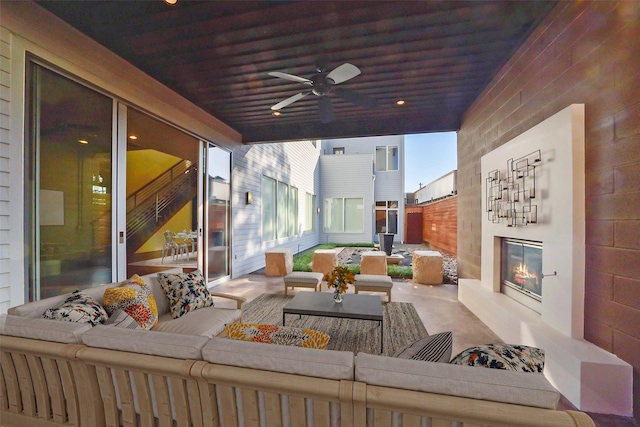 exterior space featuring an outdoor living space with a fireplace and a ceiling fan