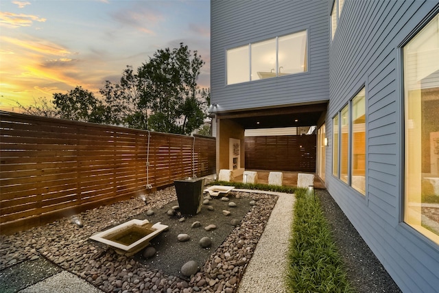 property exterior at dusk with a fenced backyard