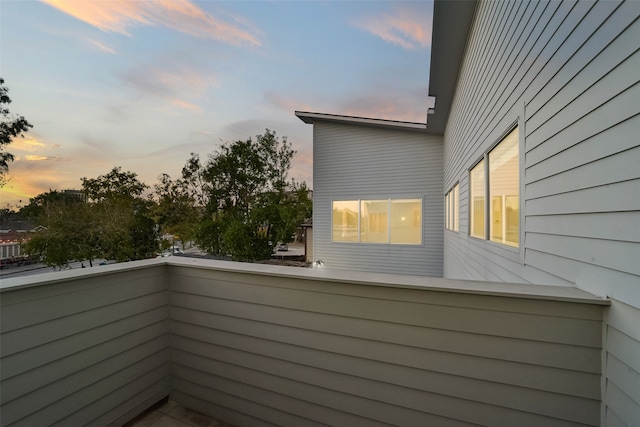 property exterior at dusk featuring a balcony