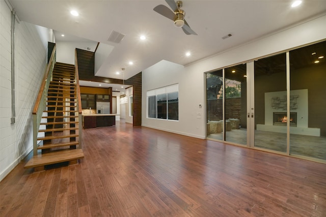 unfurnished living room with high vaulted ceiling, dark wood-type flooring, and ceiling fan