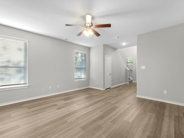 empty room with ceiling fan and light hardwood / wood-style floors