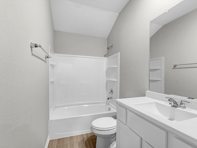 full bathroom featuring toilet, vaulted ceiling, washtub / shower combination, hardwood / wood-style floors, and vanity