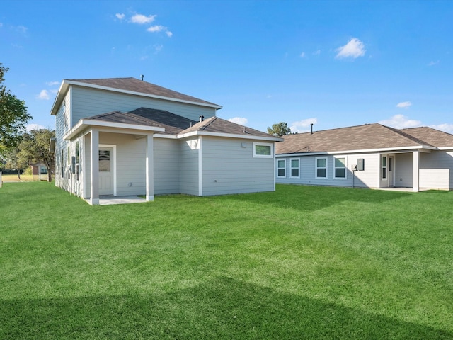 back of house with a lawn and a patio area