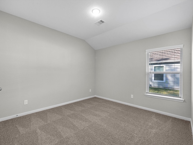 carpeted spare room with lofted ceiling