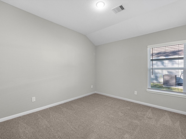 carpeted empty room with vaulted ceiling and plenty of natural light