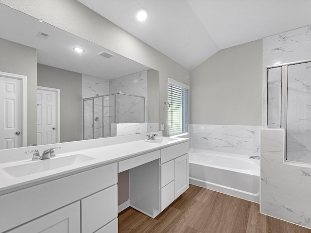 bathroom with wood-type flooring, independent shower and bath, lofted ceiling, and vanity