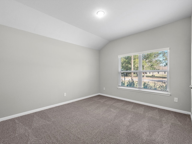 carpeted spare room featuring lofted ceiling