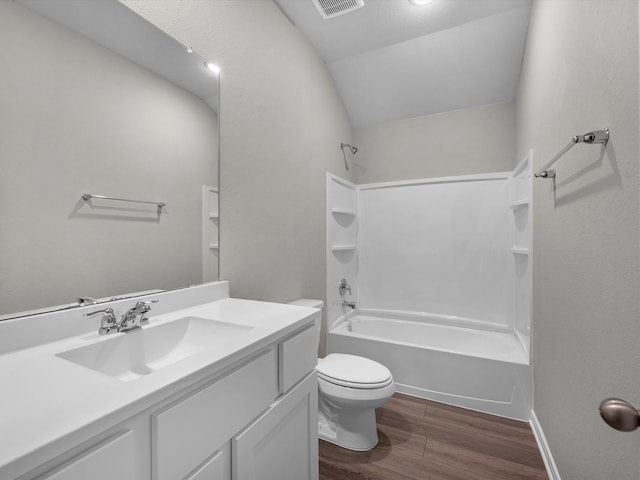 full bathroom with hardwood / wood-style floors, vaulted ceiling, toilet, vanity, and tub / shower combination