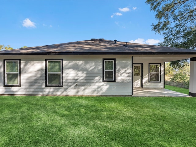 rear view of property featuring a yard