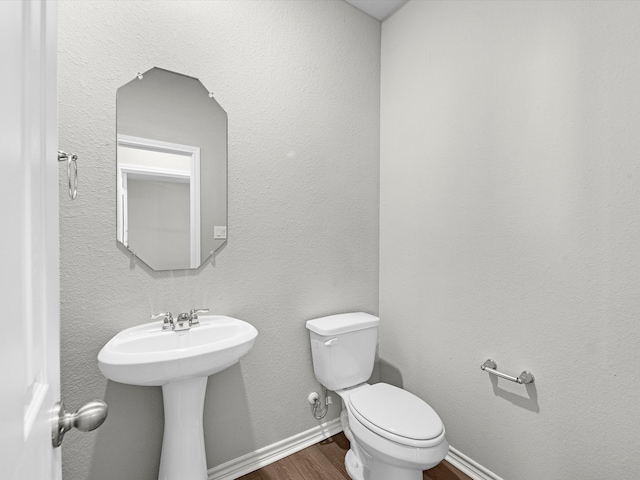 bathroom featuring toilet, hardwood / wood-style flooring, and sink