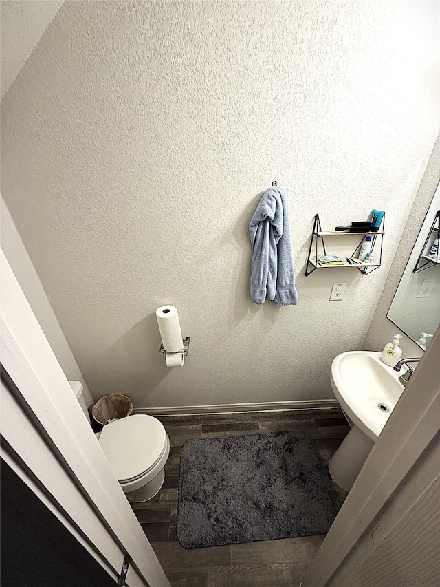 bathroom with sink, hardwood / wood-style flooring, and toilet