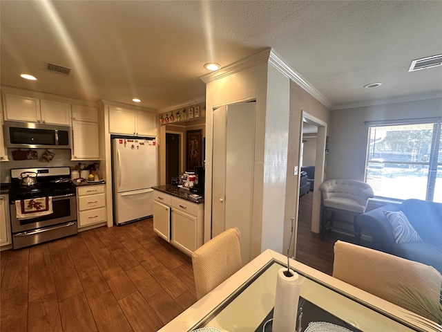 kitchen with stainless steel appliances, crown molding, dark hardwood / wood-style flooring, white cabinetry, and tasteful backsplash