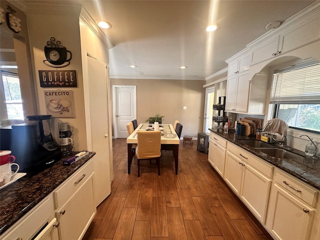 kitchen featuring ornamental molding, sink, white cabinets, and dark hardwood / wood-style floors