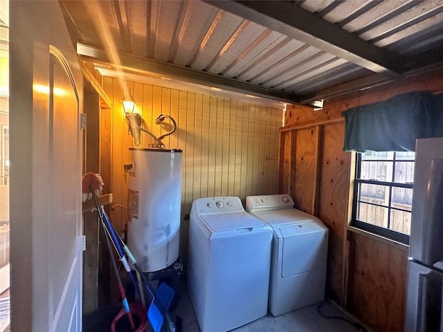 laundry area with independent washer and dryer, wood walls, and gas water heater