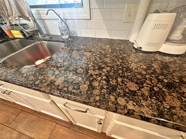 interior details featuring dark stone countertops, tile patterned floors, and sink