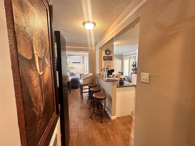 hallway featuring light hardwood / wood-style floors and a textured ceiling