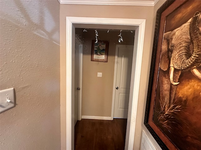 hall with dark wood-type flooring and ornamental molding