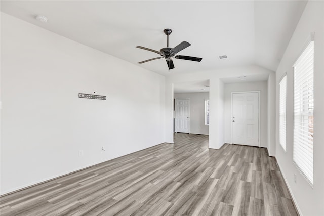 spare room featuring ceiling fan, light hardwood / wood-style floors, and lofted ceiling