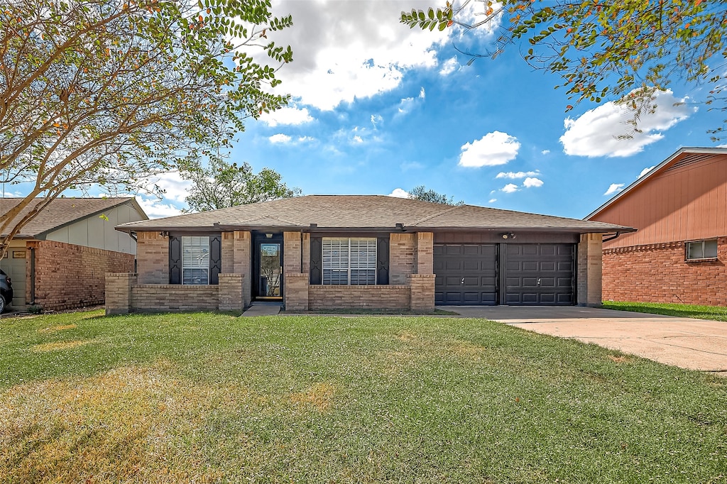 ranch-style house featuring a garage and a front lawn