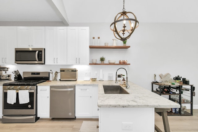 kitchen featuring sink, white cabinetry, light hardwood / wood-style floors, stainless steel appliances, and pendant lighting