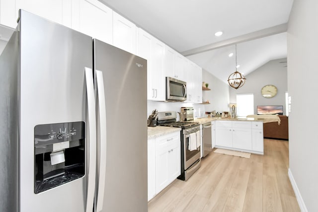 kitchen featuring appliances with stainless steel finishes, hanging light fixtures, white cabinetry, and light hardwood / wood-style floors