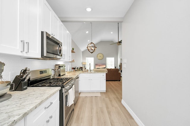 kitchen featuring white cabinetry, light hardwood / wood-style floors, stainless steel appliances, and vaulted ceiling