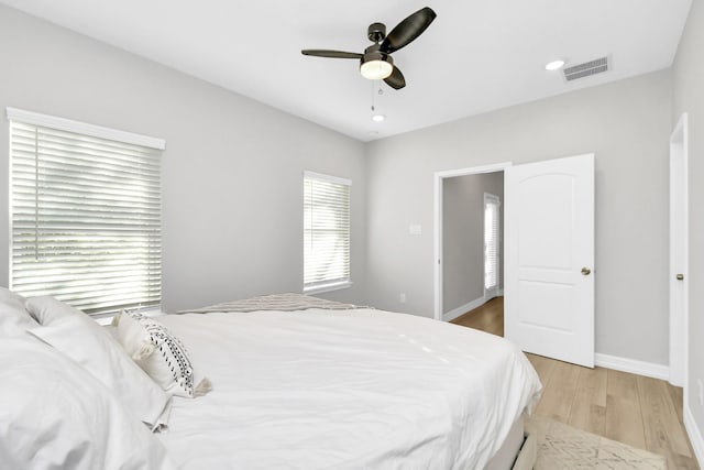 bedroom featuring visible vents, ceiling fan, light wood finished floors, and baseboards
