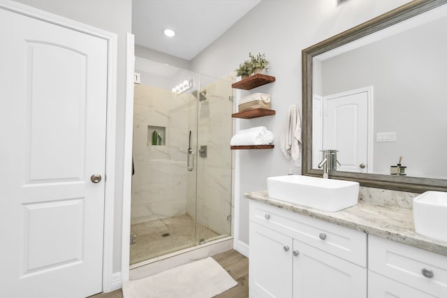 bathroom with vanity, hardwood / wood-style flooring, and a shower with door