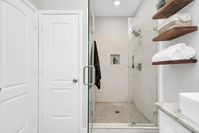 bathroom featuring recessed lighting, a marble finish shower, and vanity