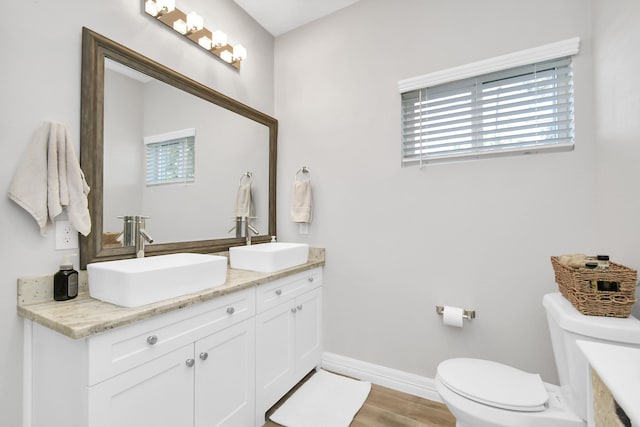 bathroom with vanity, toilet, hardwood / wood-style flooring, and a wealth of natural light