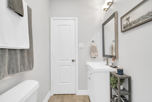 bathroom featuring vanity, hardwood / wood-style flooring, and toilet