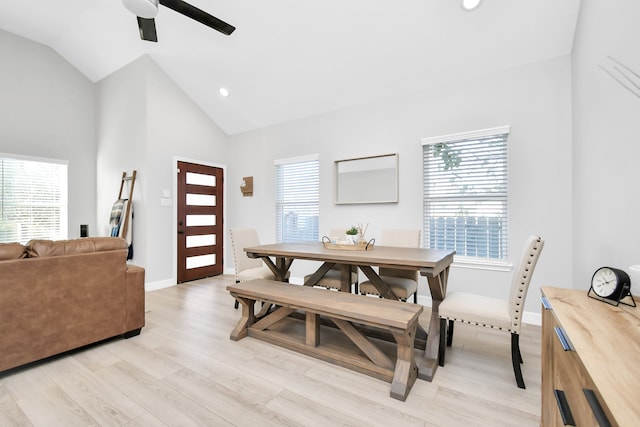 dining room with high vaulted ceiling, light hardwood / wood-style floors, and ceiling fan