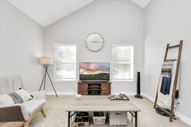 living room featuring hardwood / wood-style floors, high vaulted ceiling, and a healthy amount of sunlight