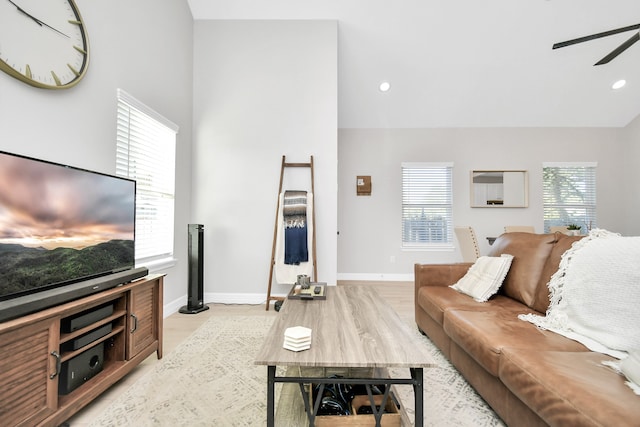 living room with ceiling fan, light wood-type flooring, and plenty of natural light