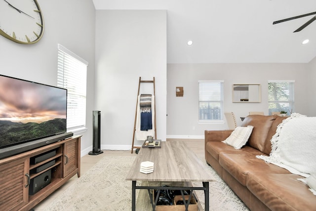 living room featuring light wood-type flooring, a ceiling fan, recessed lighting, and baseboards