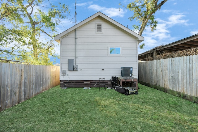 back of property featuring a lawn and central AC unit