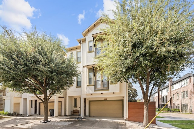 2523 Maxroy St, Houston, TX 77007 - view of property featuring stucco siding, a garage, concrete driveway, and a balcony