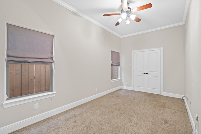 carpeted empty room with crown molding, ceiling fan, and a healthy amount of sunlight