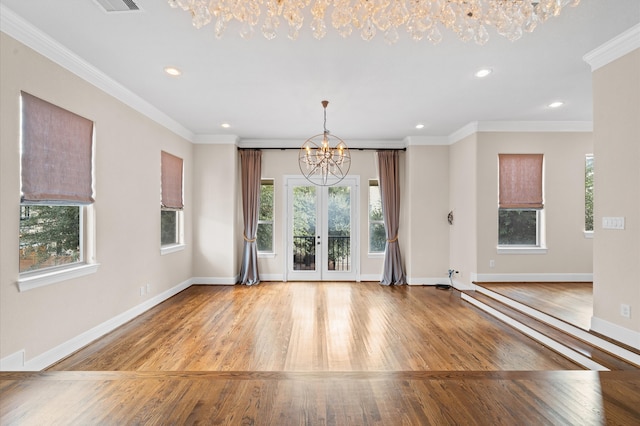 interior space with french doors, ornamental molding, a chandelier, and light hardwood / wood-style flooring