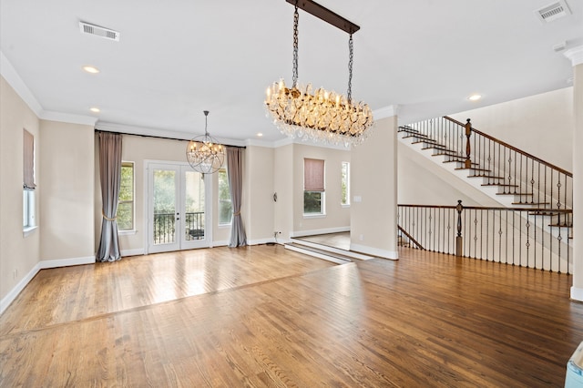 foyer entrance with crown molding, a chandelier, and hardwood / wood-style floors