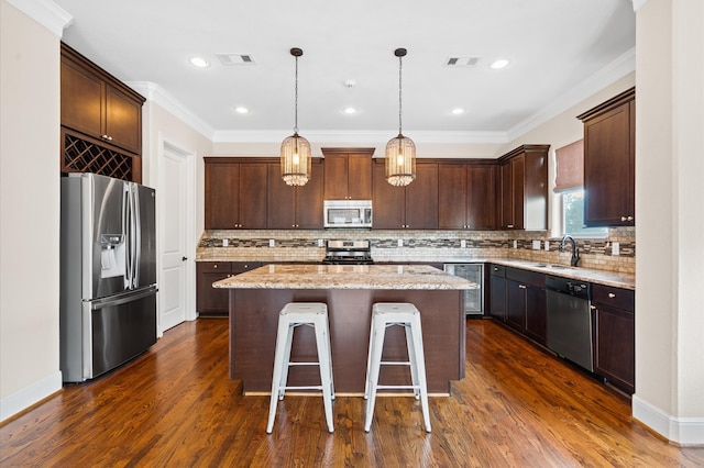 kitchen featuring light stone counters, hanging light fixtures, a kitchen island, stainless steel appliances, and beverage cooler