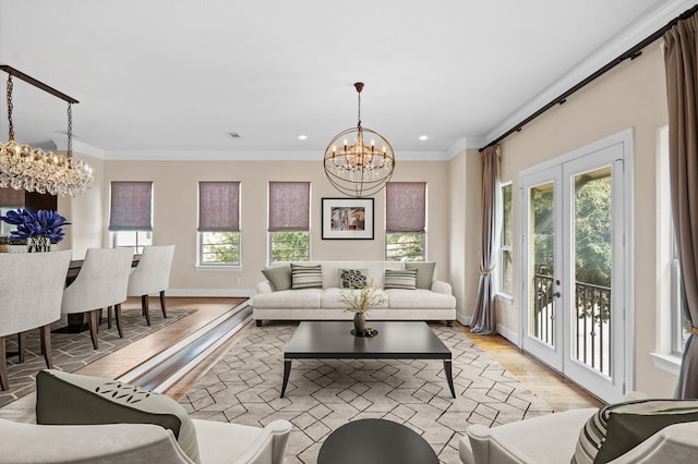 living room featuring a notable chandelier, crown molding, french doors, and light wood-type flooring