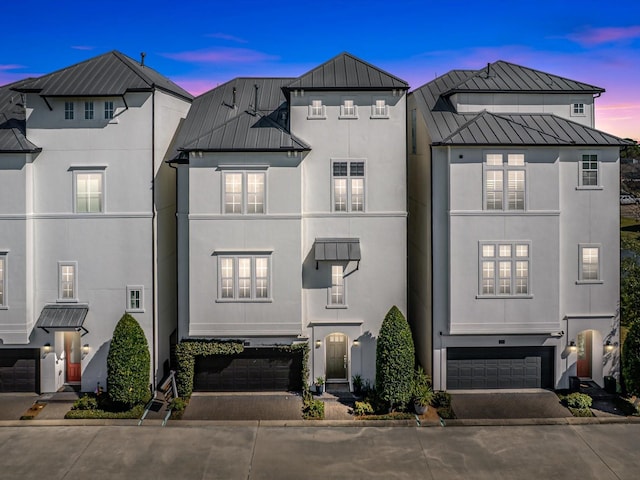 townhome / multi-family property with a standing seam roof, metal roof, and stucco siding