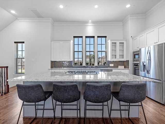 kitchen featuring glass insert cabinets, a spacious island, appliances with stainless steel finishes, and white cabinets