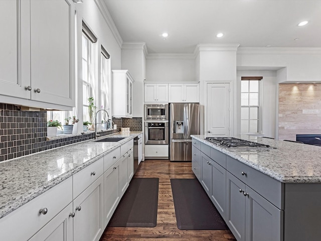 kitchen featuring light stone counters, a sink, white cabinetry, appliances with stainless steel finishes, and gray cabinets